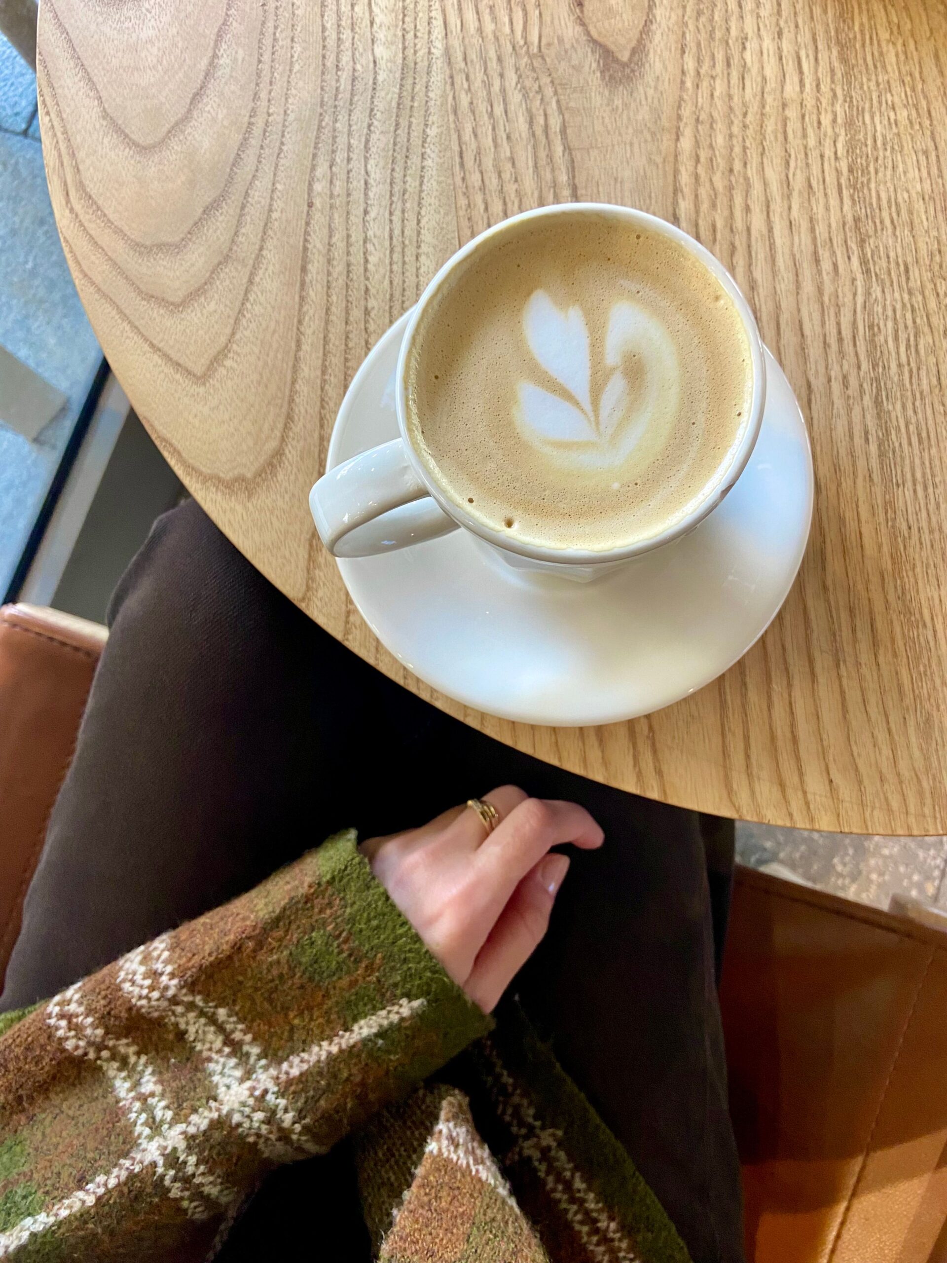A warm cup of latte art coffee on a wooden cafe table